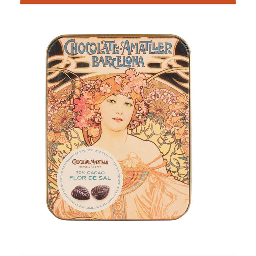 A rectangular metal tin of Chocolate Amâtier Barcelona chocolate, featuring an Art Nouveau illustration of a woman with flowers and the text 'CHOCOLATE-AMÂTIER BARCELONA' and '70% CACAO FLOR DE SAL'.